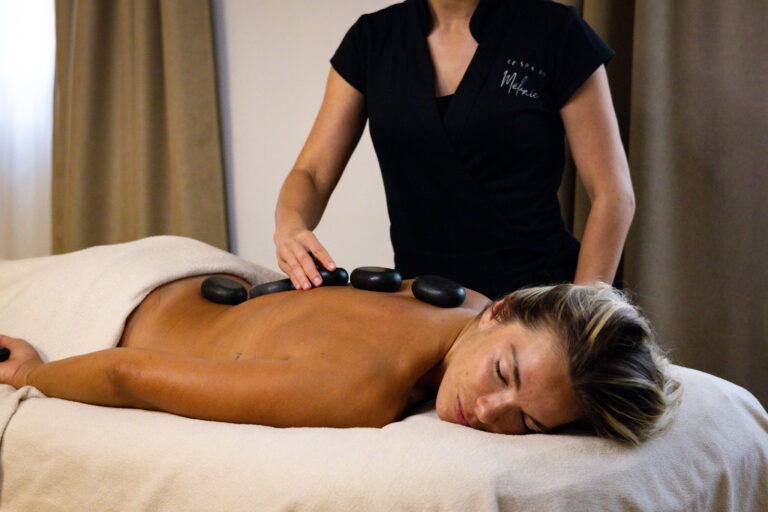 Massage aux pierres chaudes à Nîmes au Spa de Mélanie – pierres volcaniques posées sur le dos pour un moment de détente et de chaleur bienfaisante.