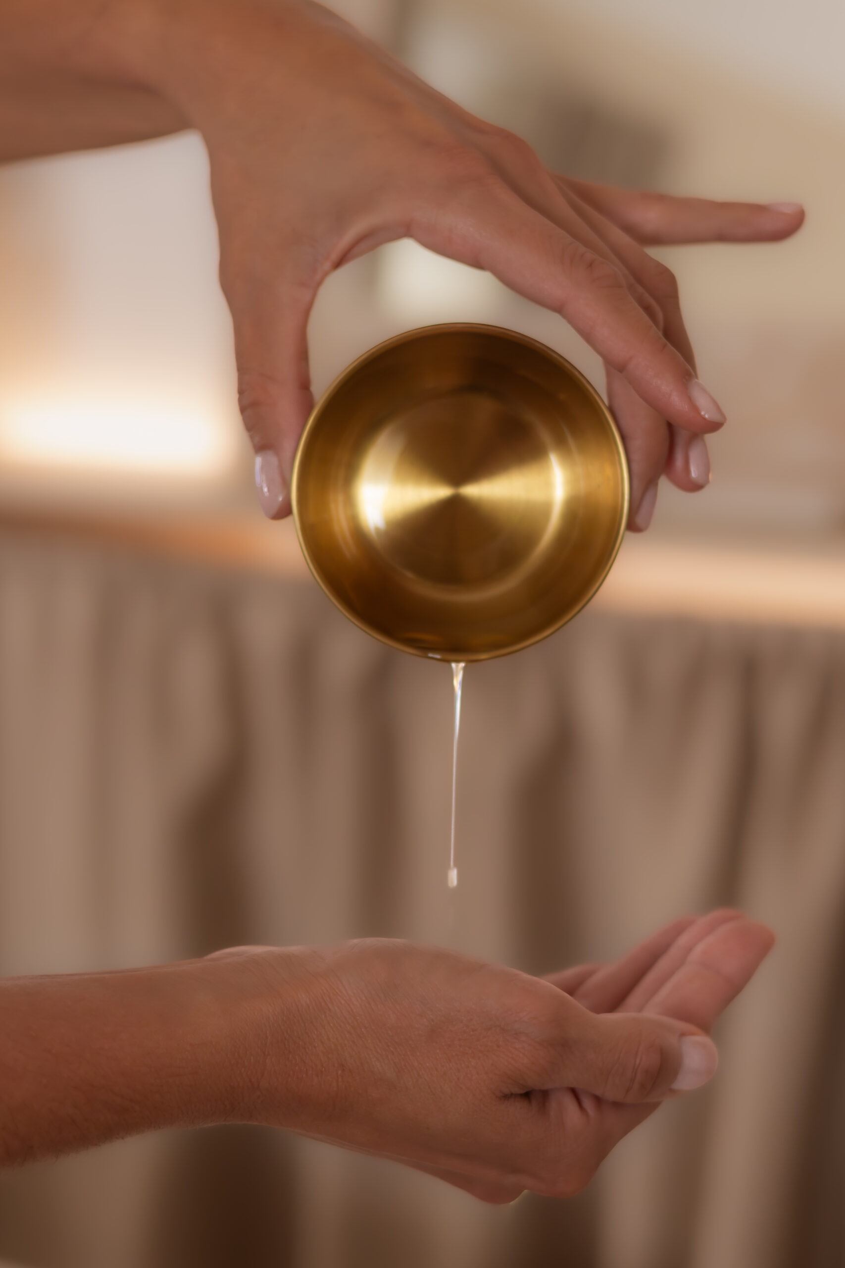 Huile de massage versée dans les mains d’une praticienne au Spa de Mélanie à Nîmes